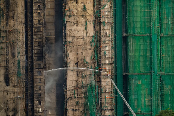 Firefighters work to extinguish a fire which broke out Wednesday at Wang Fuk Court, a residential estate in the Tai Po district of Hong Kong's New Territories, Thursday, Nov. 27, 2025. (AP Photo/Chan Long Hei)